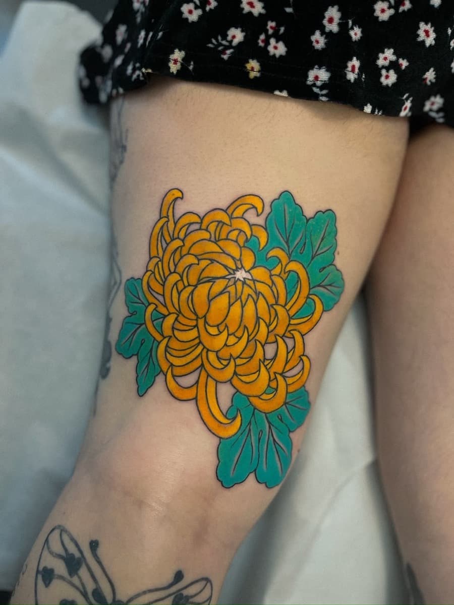 Crisântemo amarelo no joelho, tatuagem do Sergio Miron