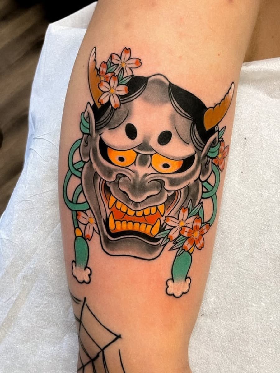 Máscara hannya com flores de cerejeira no antebraço, tatuagem do Sergio Miron
