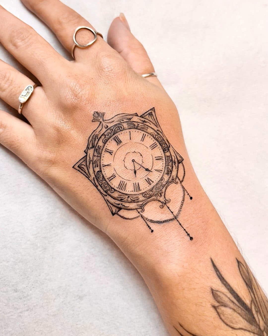 Relógio ornamental tatuado na mão, criado por Júlia Domingues
