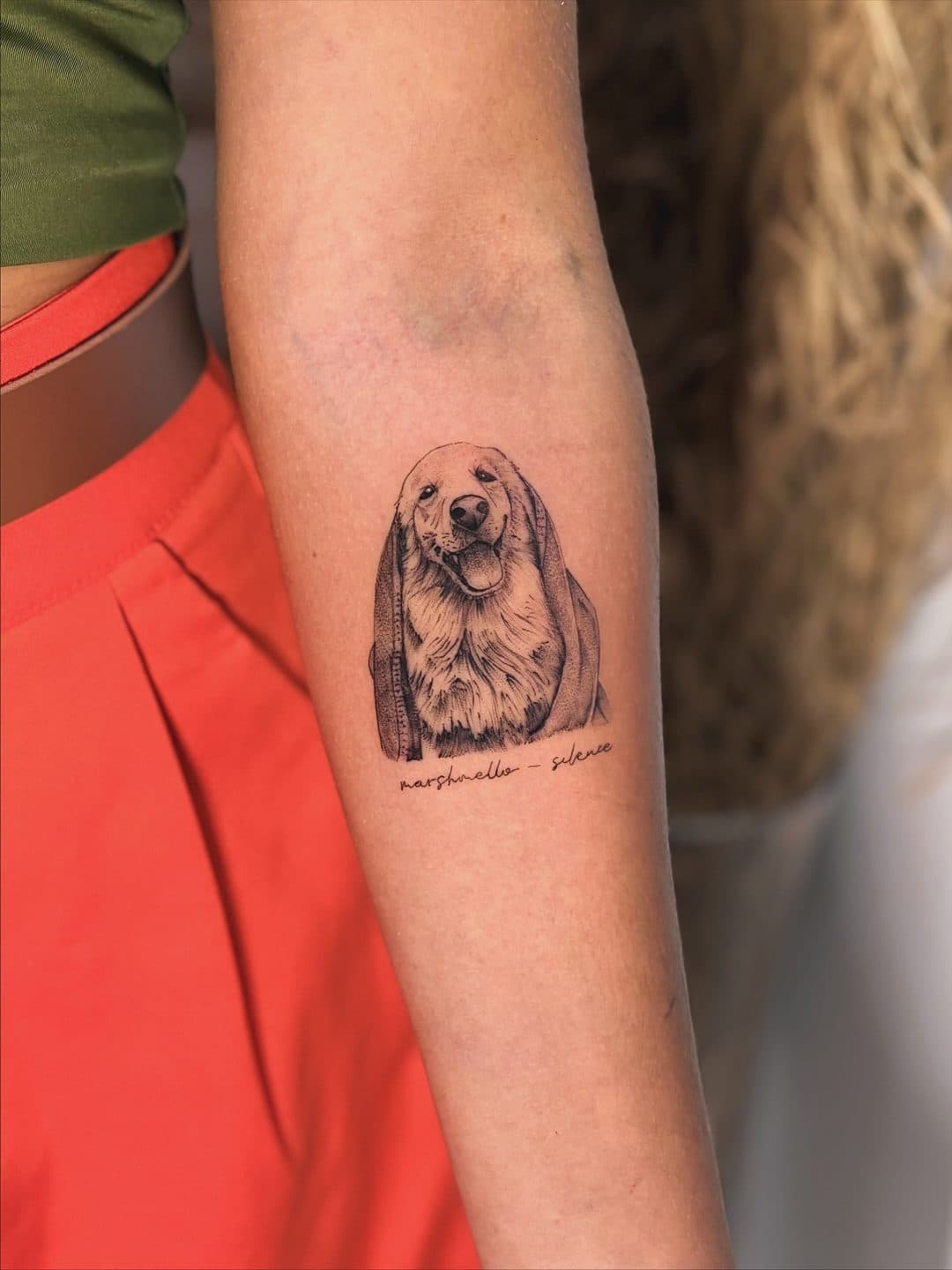 Retrato realista do cachorro Luke com o nome escrito à mão, tatuado no antebraço por Ramon Ximenes no Studio Gojira